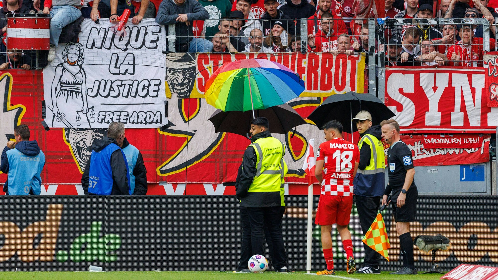 Mainz-Profi Nadiem Amiri wird bei seinem zweiten Versuch, eine Ecke auszuführen mit Schirmen geschützt.