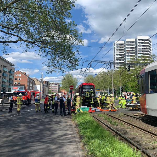 Feuerwehrmänner und Polizisten vor einer Straßenbahn.