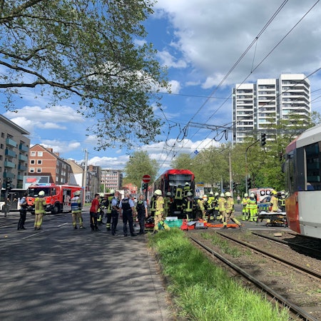 Feuerwehrmänner und Polizisten vor einer Straßenbahn.