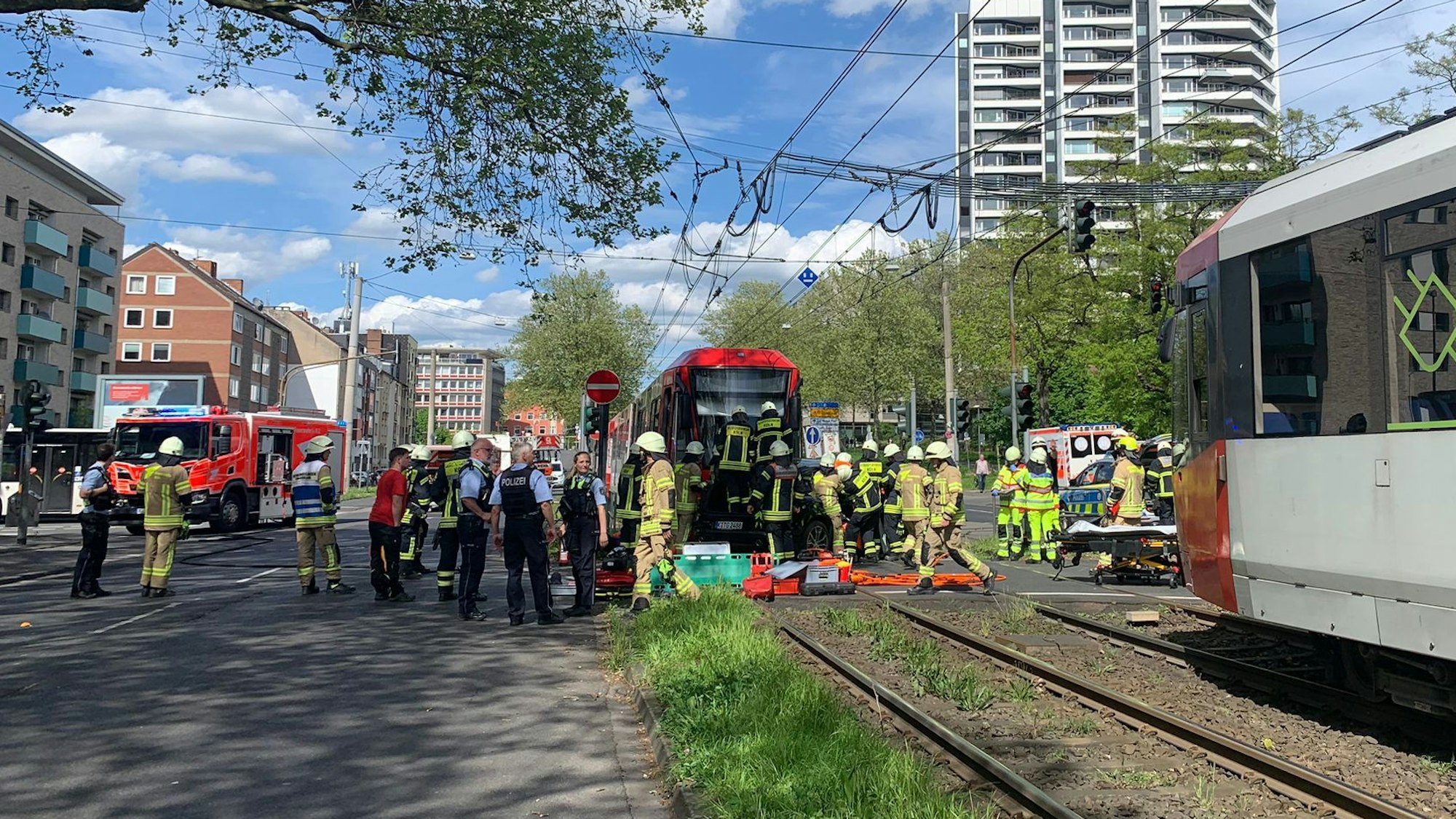 Feuerwehrmänner und Polizisten vor einer Straßenbahn.