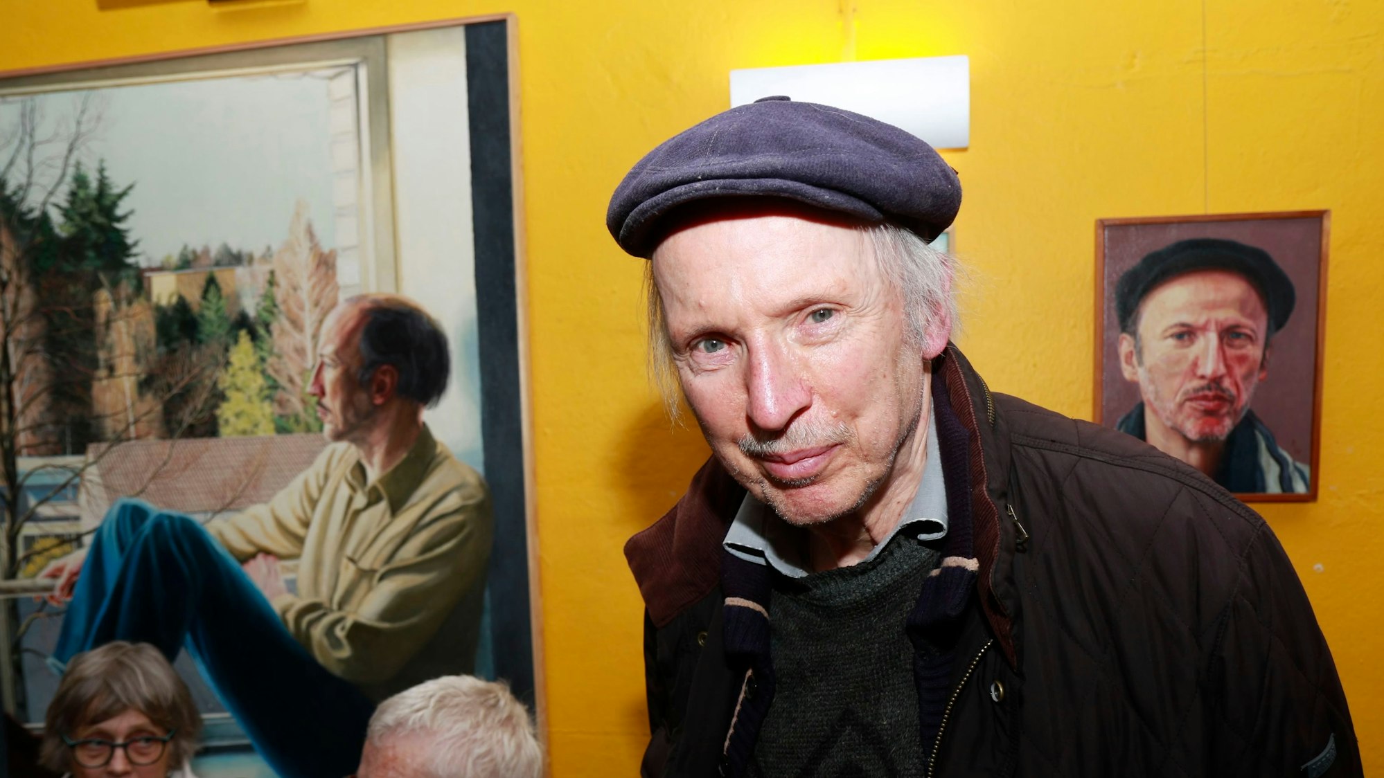 Michael Mohr steht vor zwei Bildern in der Ausstellung.