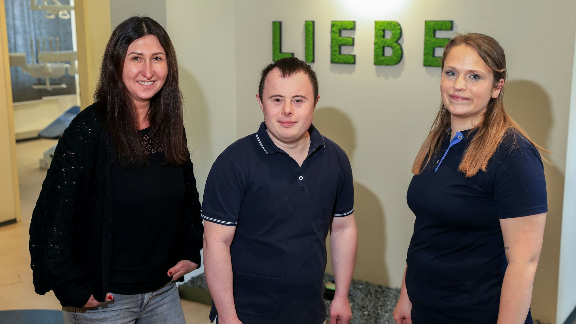 Dennis Meurer hat das Down-Syndrom und arbeitet in einer Kölner Zahnarztpraxis.
Im Bild ist er mit den Kolleginnen Sanela Isic und  Yvonne Gülden zu sehen.