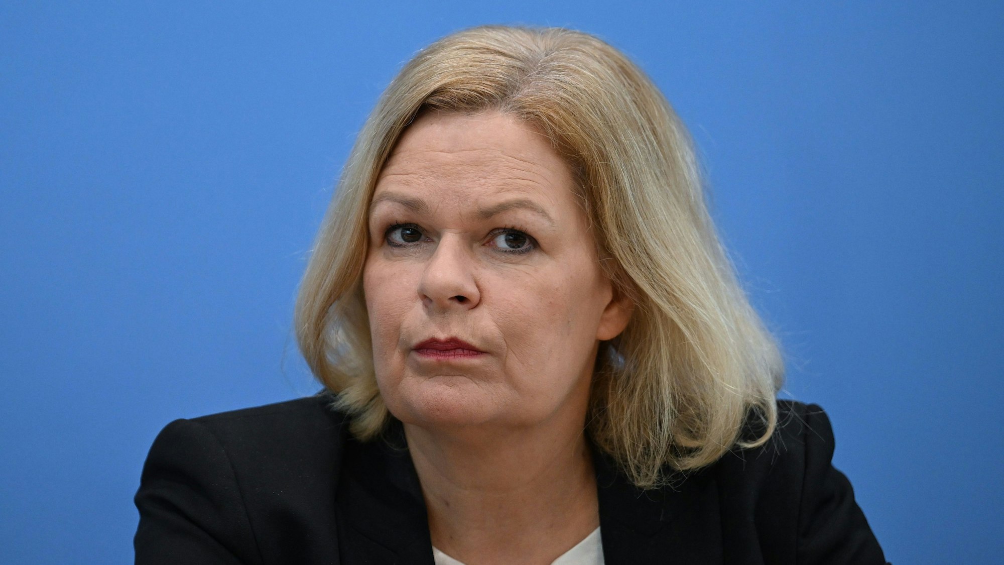 Zu sehen ist Nancy Faeser (SPD), Bundesministerin des Innern und Heimat, vor einem blauen Hintergrund.