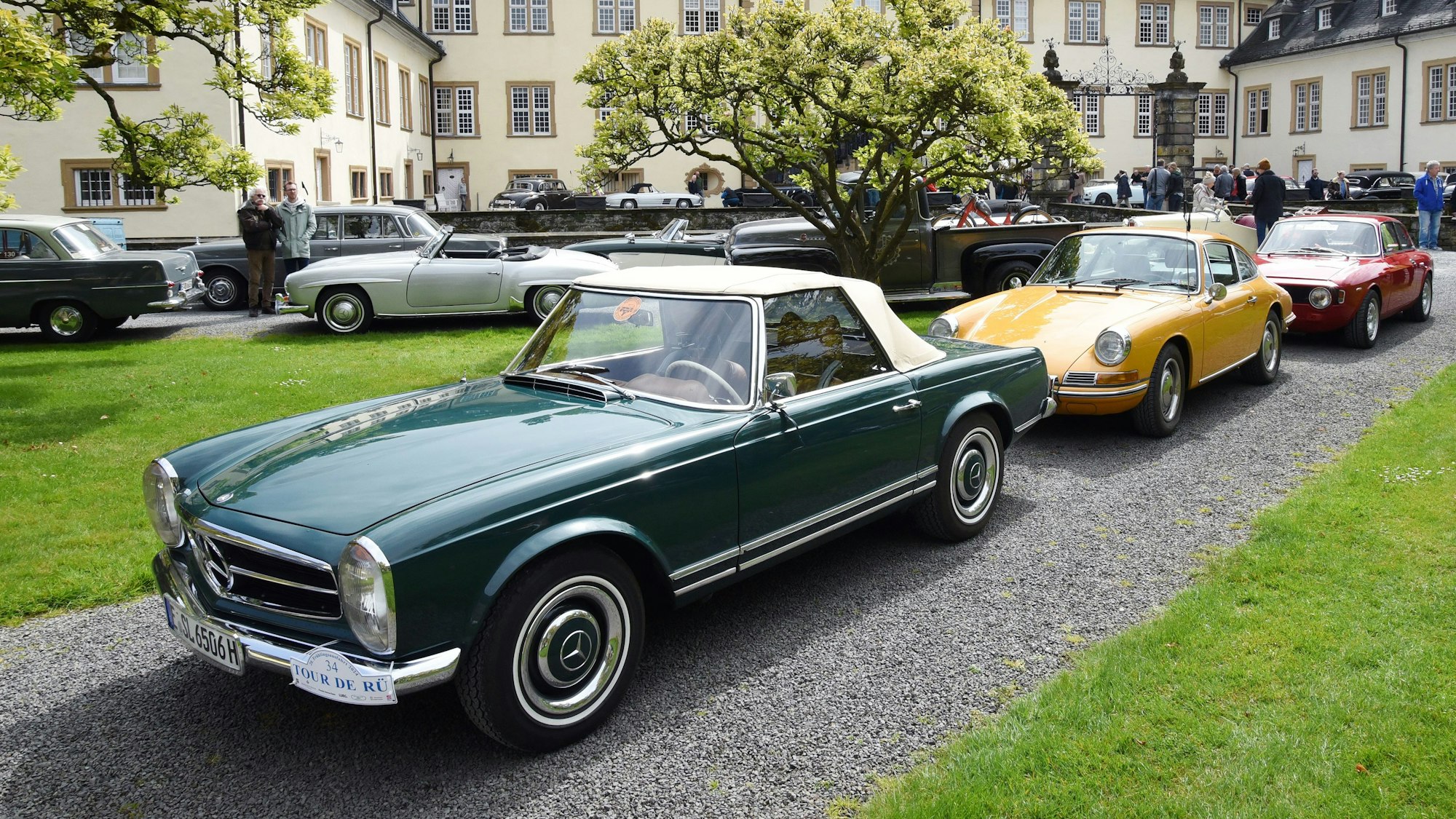 Oldtimer stehen Stoßstange an Stoßstange im Innenhof von Schloss Ehreshoven bei Engelskirchen.