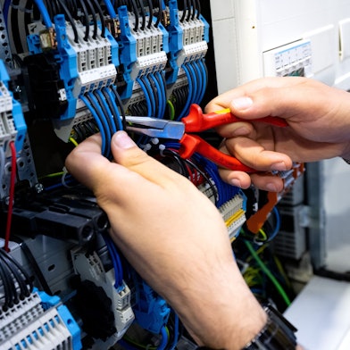 Ein Mann arbeitet an einem an einem Stromkasten (Symbolbild).