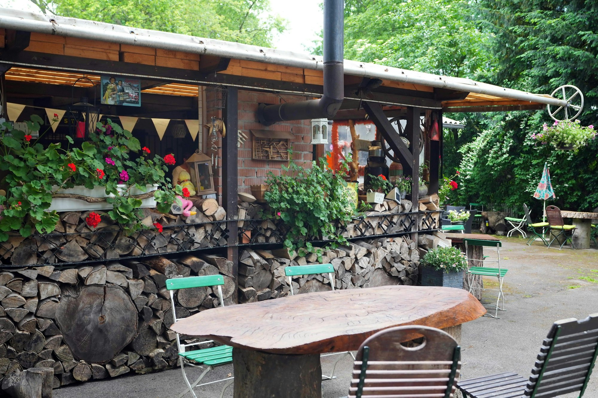 Der Biergarten im Steinbud "Zur grünen Oase", Holztische, Stühle und Mauern.