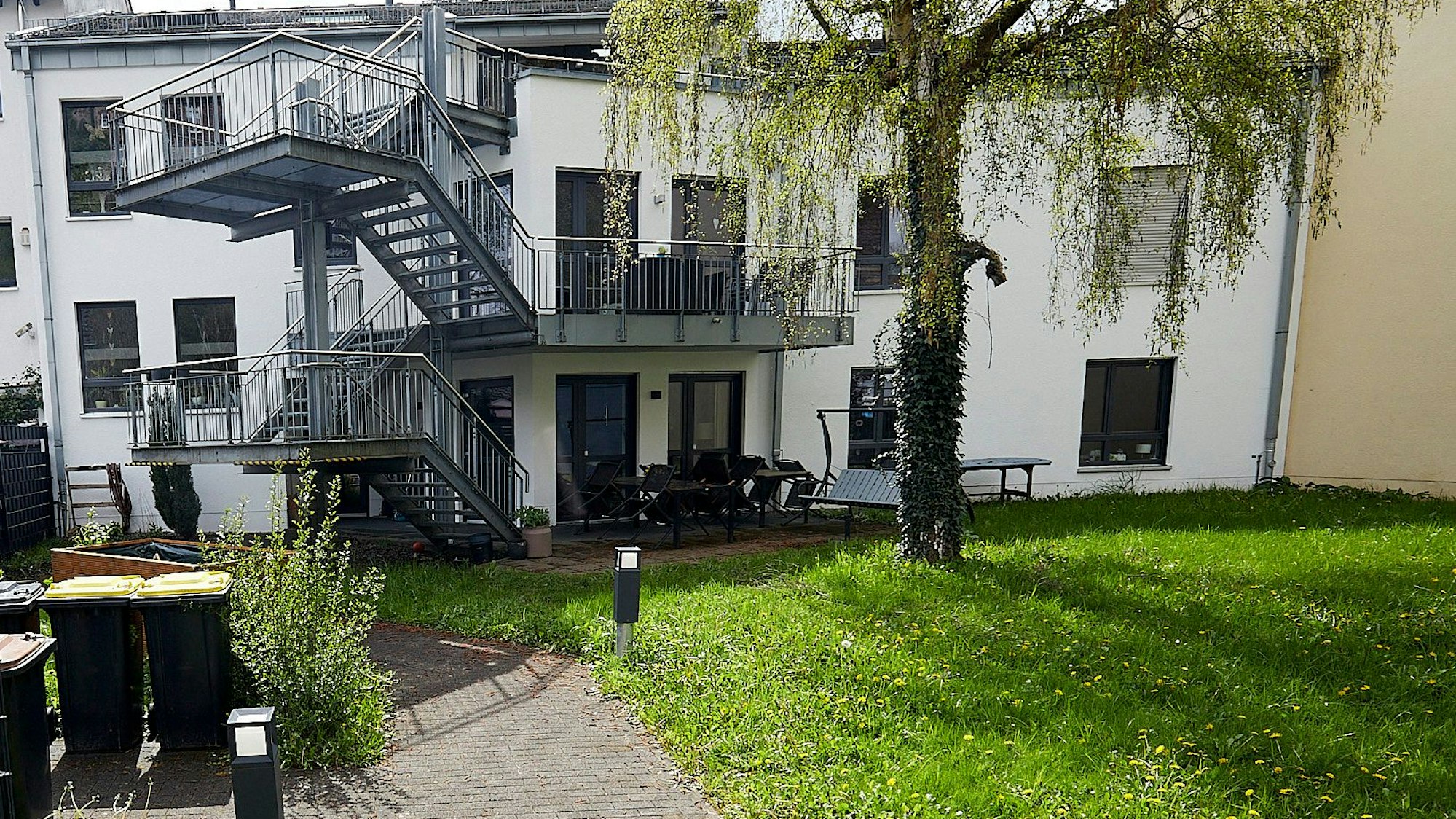Das Bild zeigt das zweigeschossige Gebäude mit einer Außentreppe.
