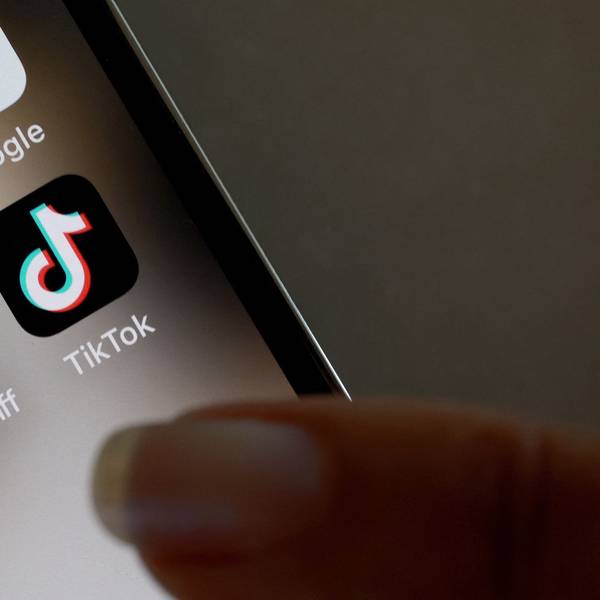 Ein Finger zeigt auf ein TikTok-Icon auf einem Handy.