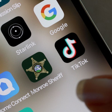 Ein Finger zeigt auf ein TikTok-Icon auf einem Handy.