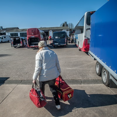 Eine Frau trägt zwei Reisetaschen.