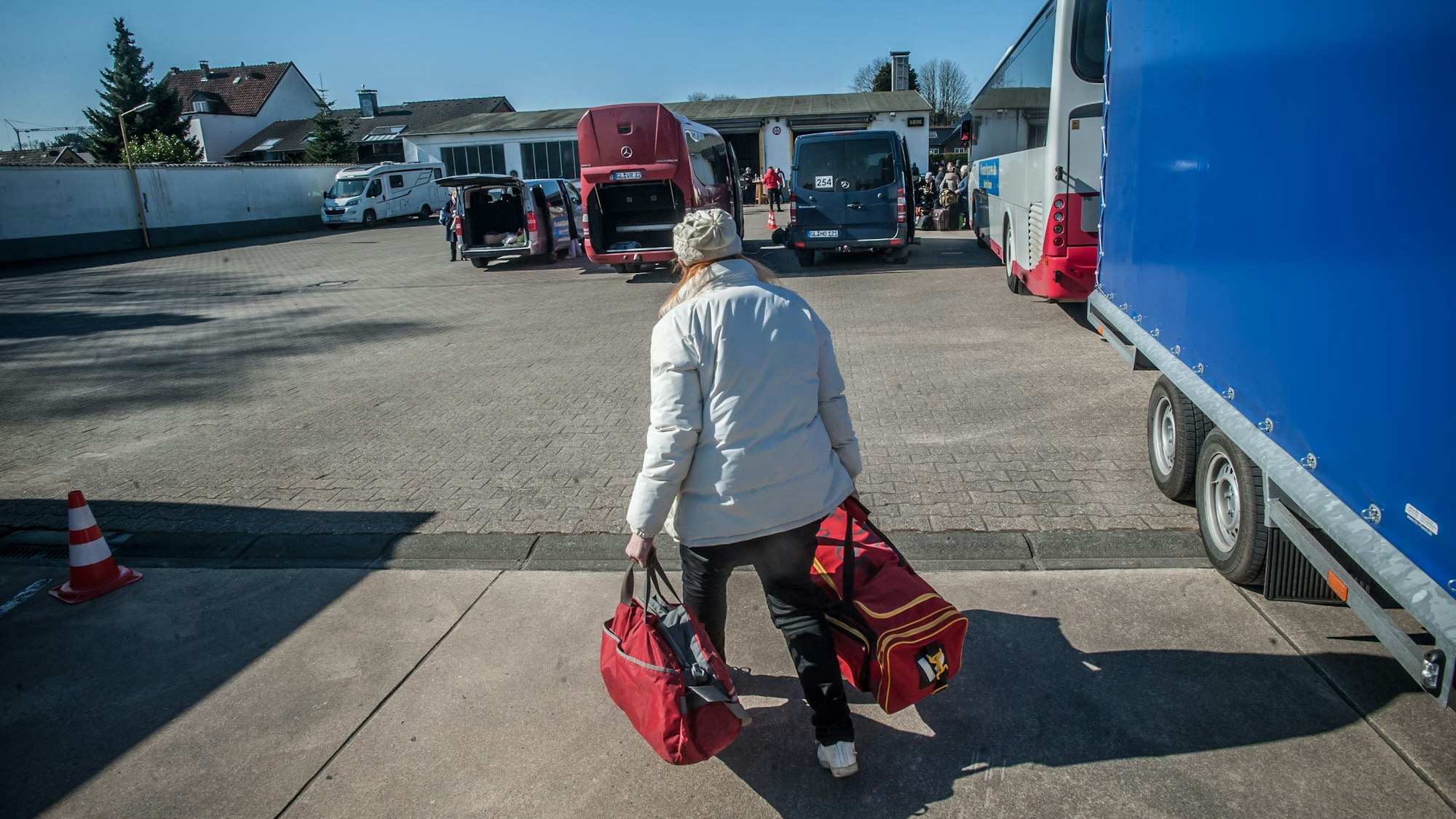 Eine Frau trägt zwei Reisetaschen.