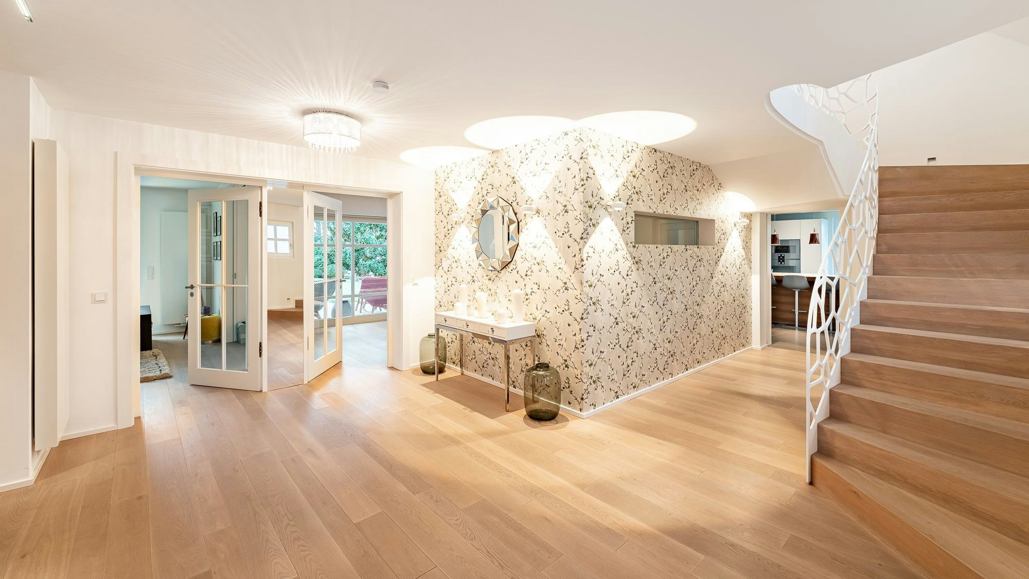 Das Entrée einer Immobilie in Sankt Augustin: Eine Holztreppe mit weißem Geländer führt ins Obergeschoss.