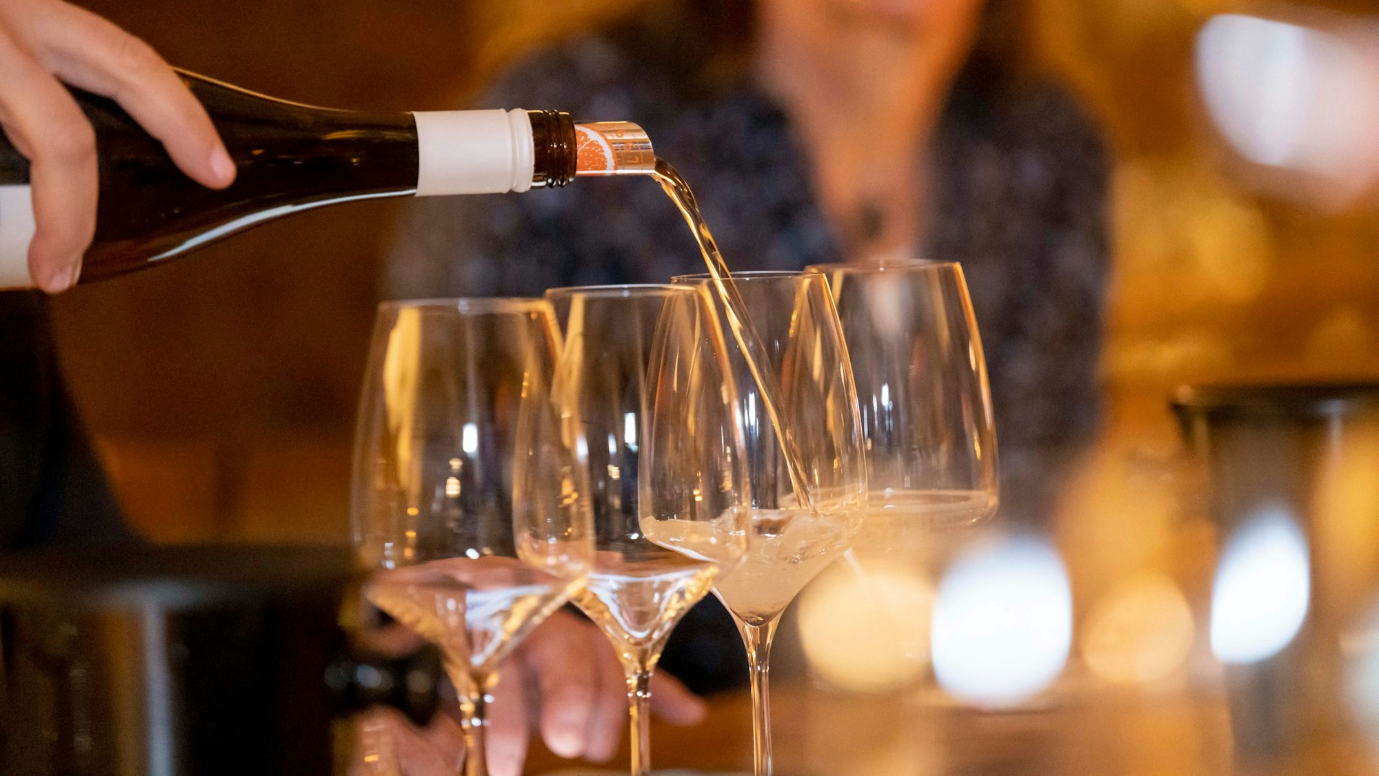 Wein wird in Gläser gefüllt.
