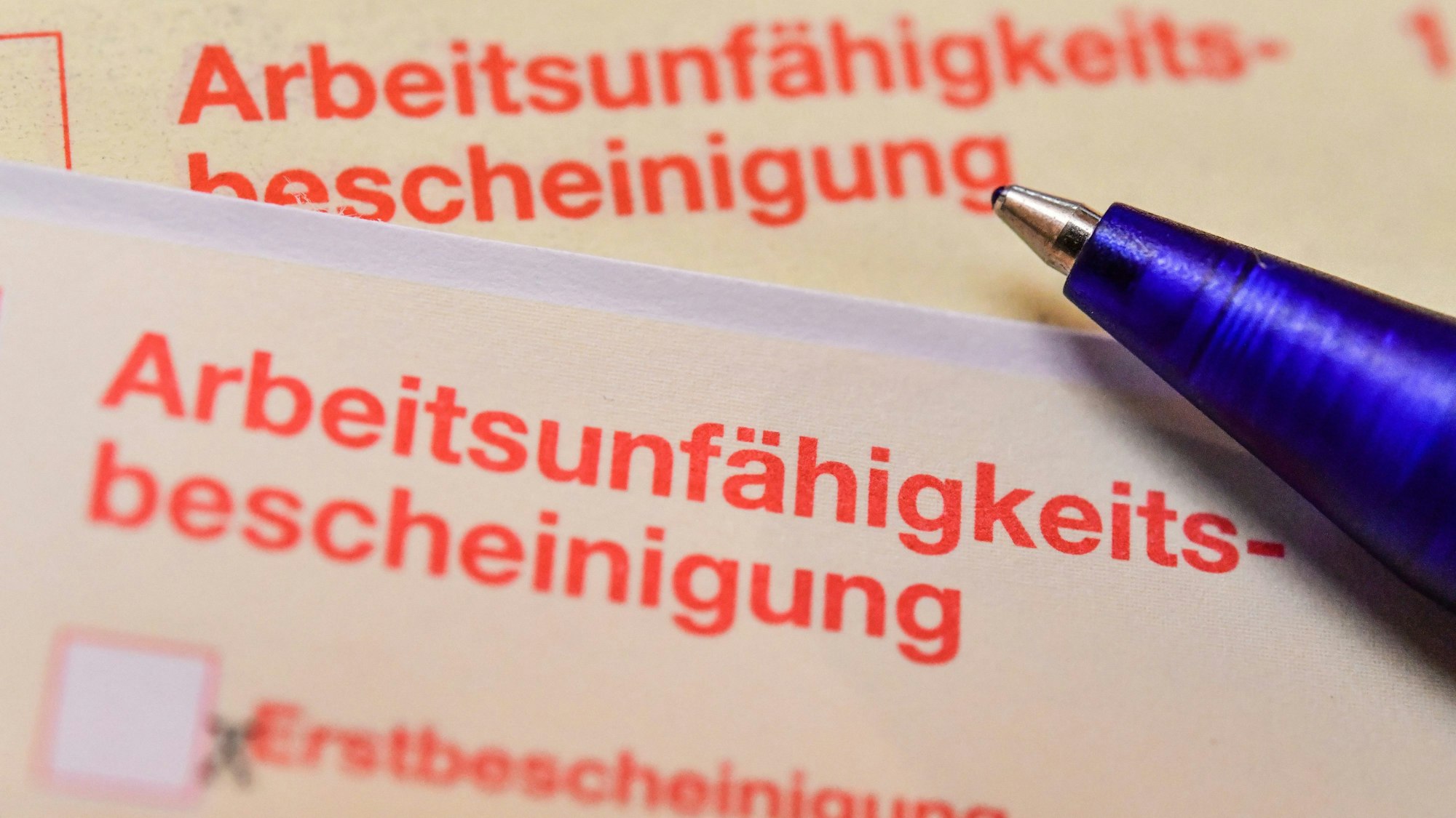 Eine Arbeitsunfähigkeitsbescheinigung liegt auf einem Tisch.