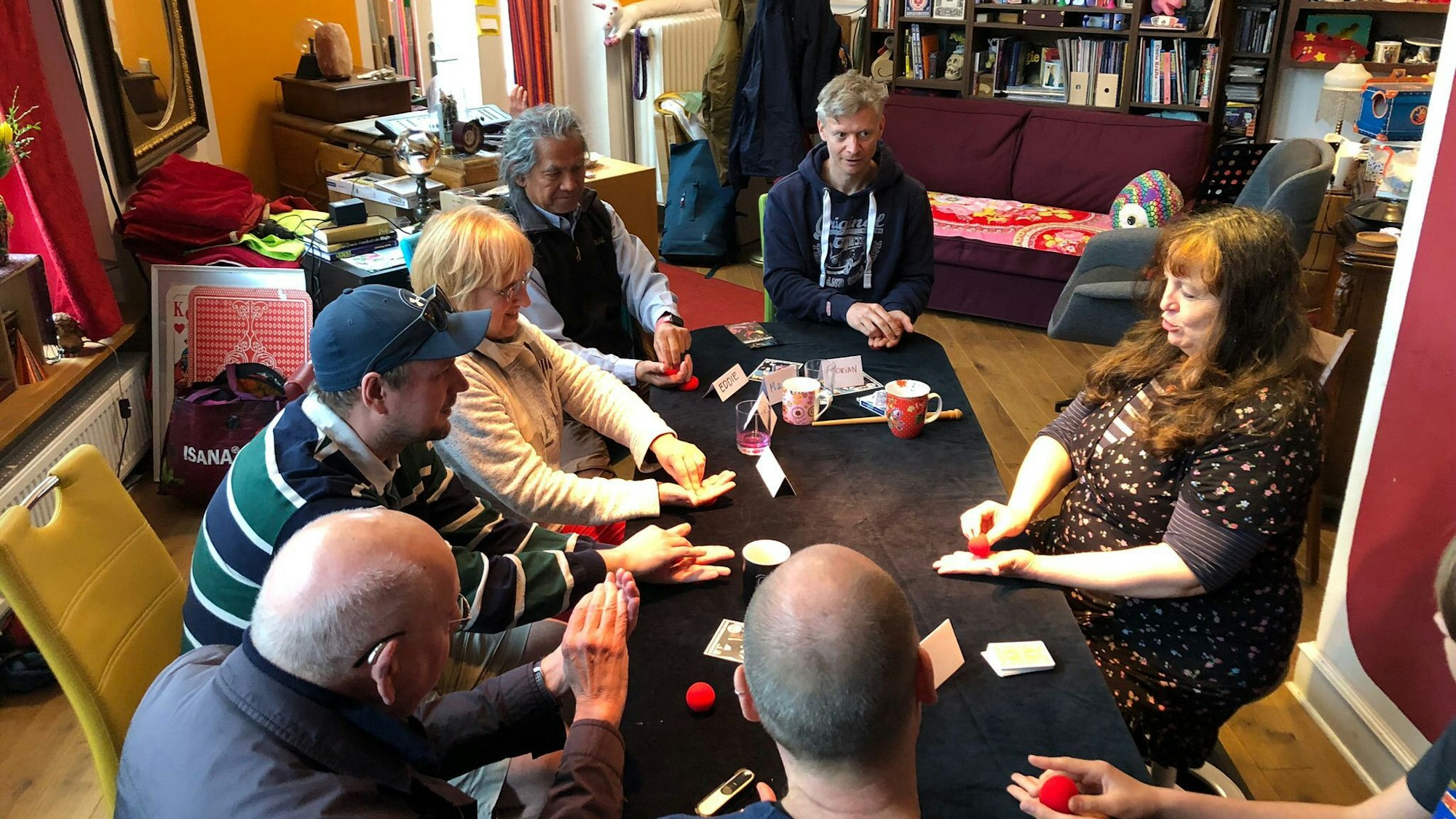 Astrid Gloria und ihre Kursteilnehmer sitzen an einem Tisch.