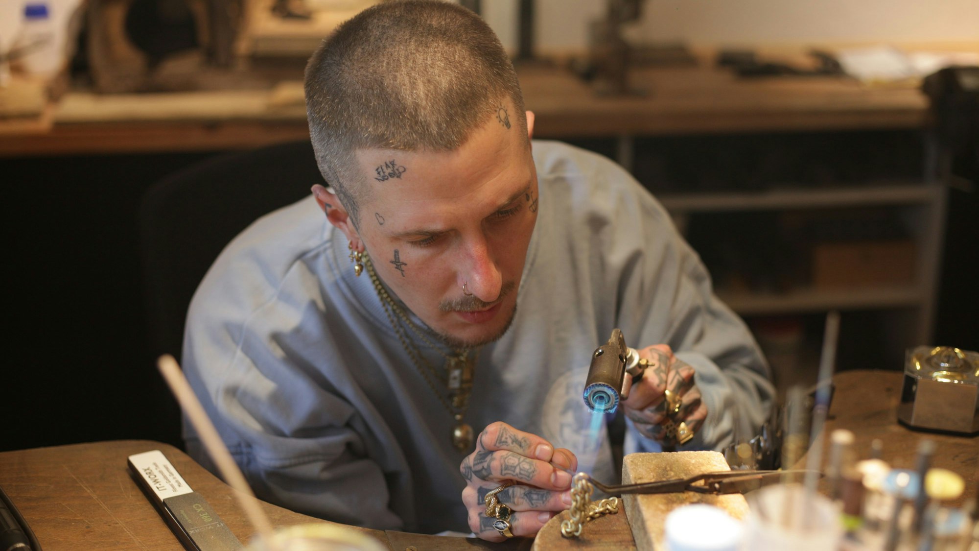 Ludwig Friedländer, Goldschmied und Schmuckdesigner, bearbeitet ein Goldarmband am Werkstisch.