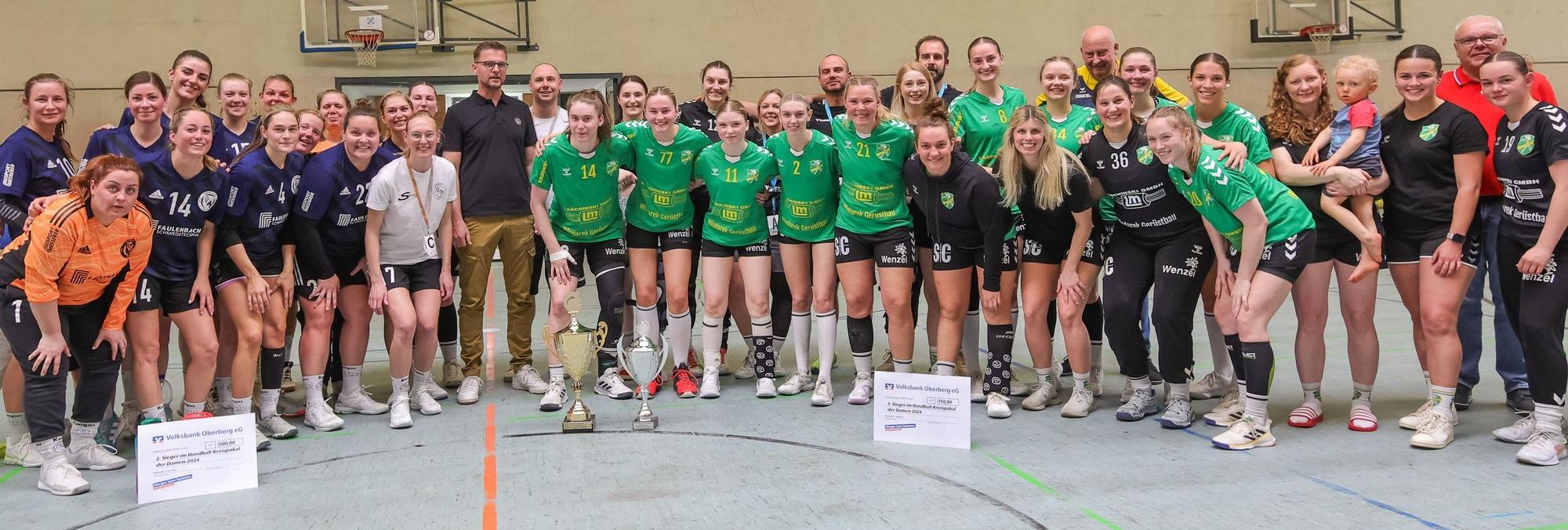 Beide Mannschaften haben sich mit ihren Siegerschecks und dem Pokal in der Halle aufgestellt.