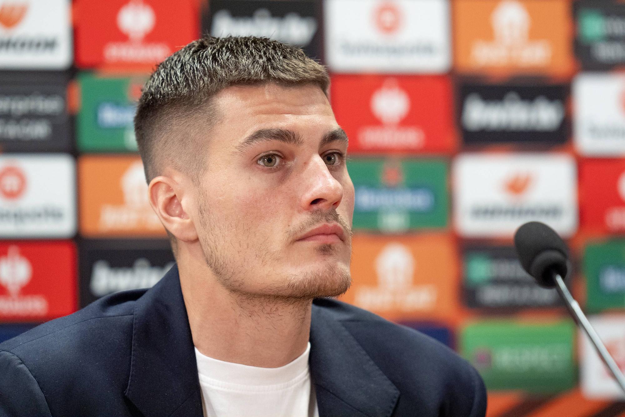 Patrick Schick sitzt bei der Pressekonferenz vor dem Spiel von Bayer 04 Leverkusen gegen Rom bei der Pressekonferenz vor dem Mikrofon.