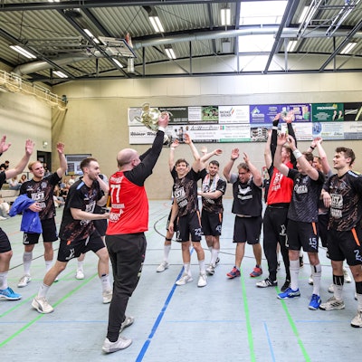 In der Mitte steht der Nümbrechter Torhüter und recht den Pokal zur Freude seiner Mansnchaftskollegen in die Höhe.