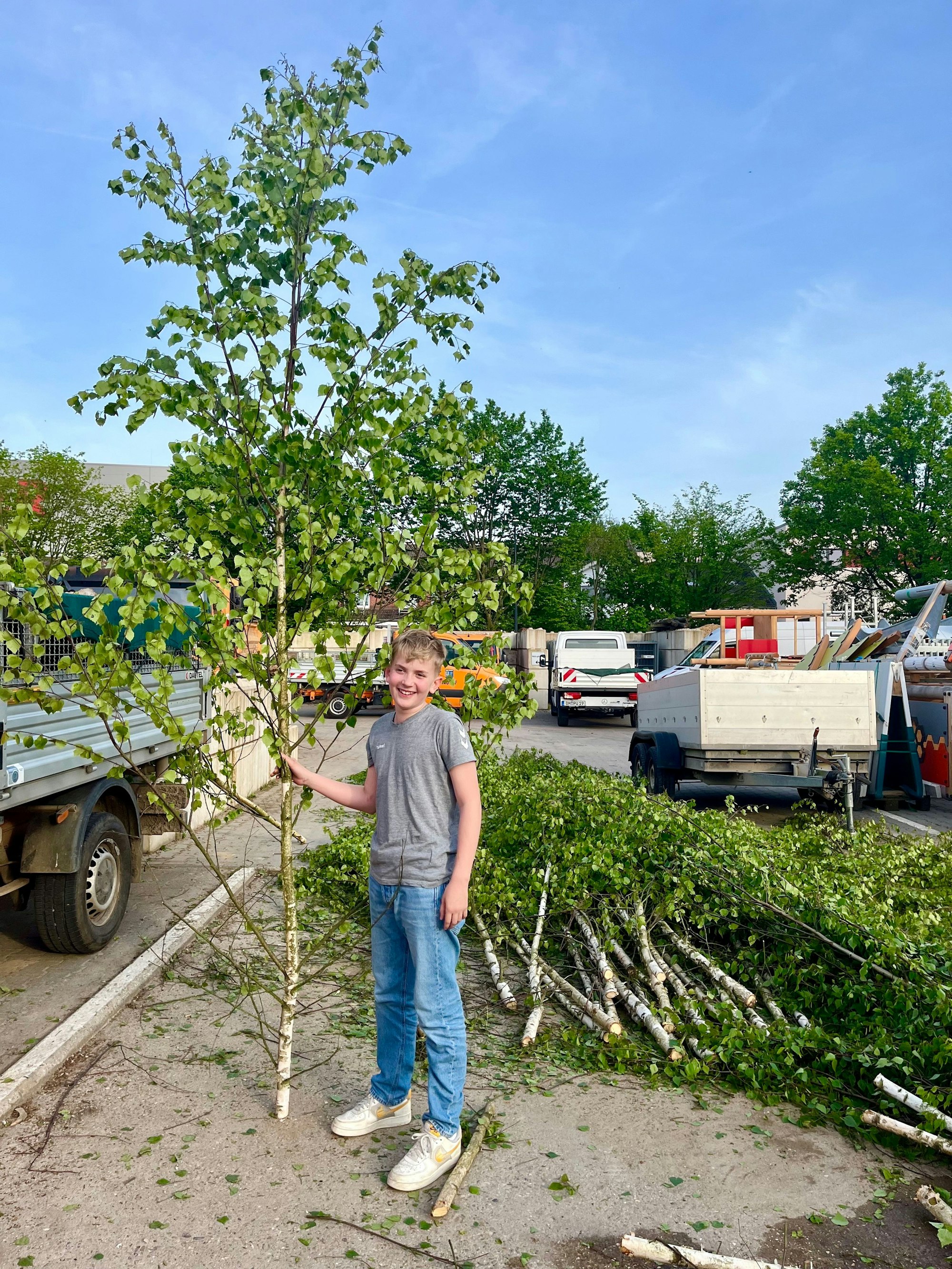 Auf dem Foto ist ein Junge zu sehen, der den Maibaum, den er sich ausgesucht hat, zeigt.
