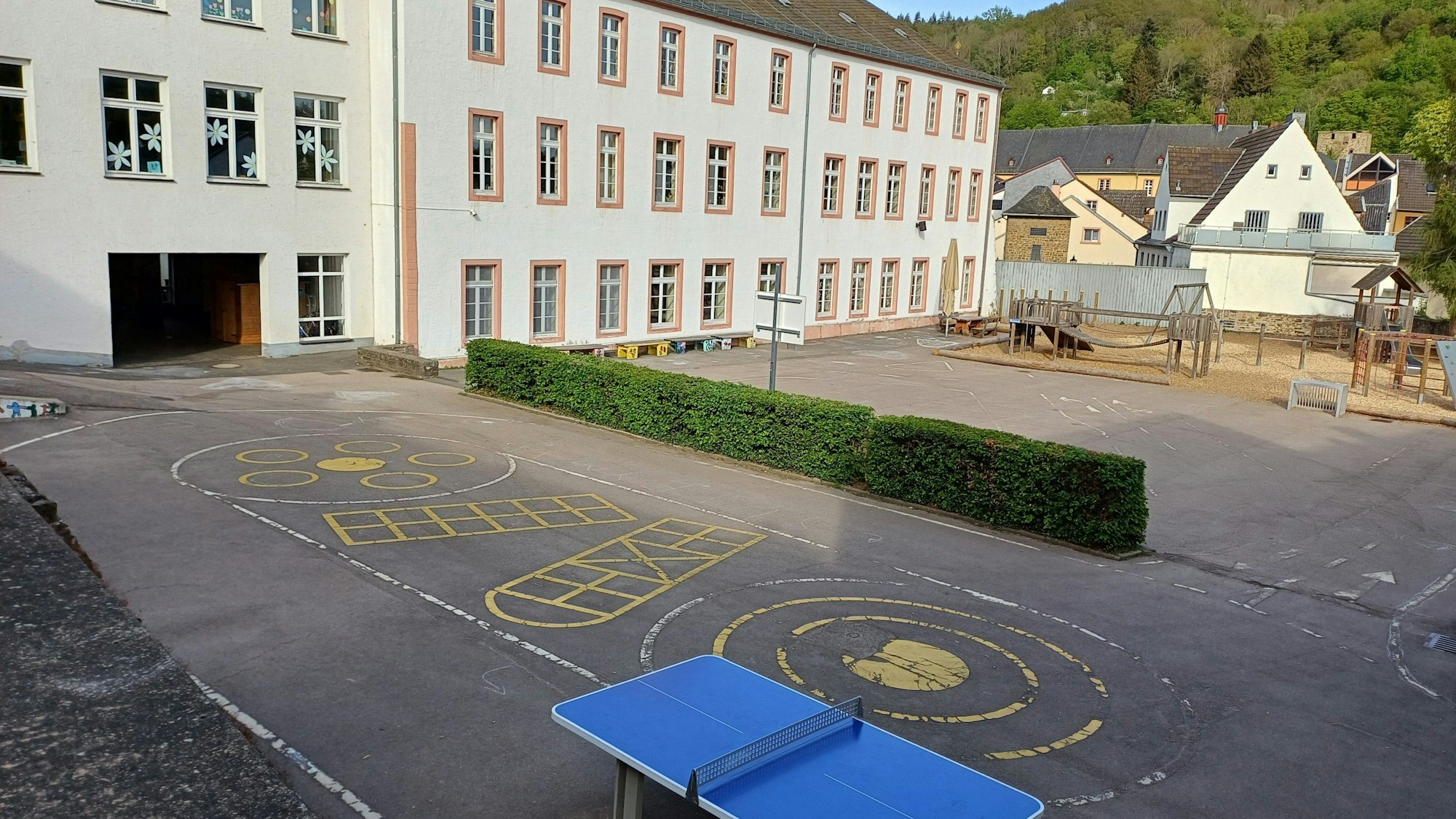 Das Bild zeigt den Blick auf die Grundschule mit dem Schulhof im Vordergrund.