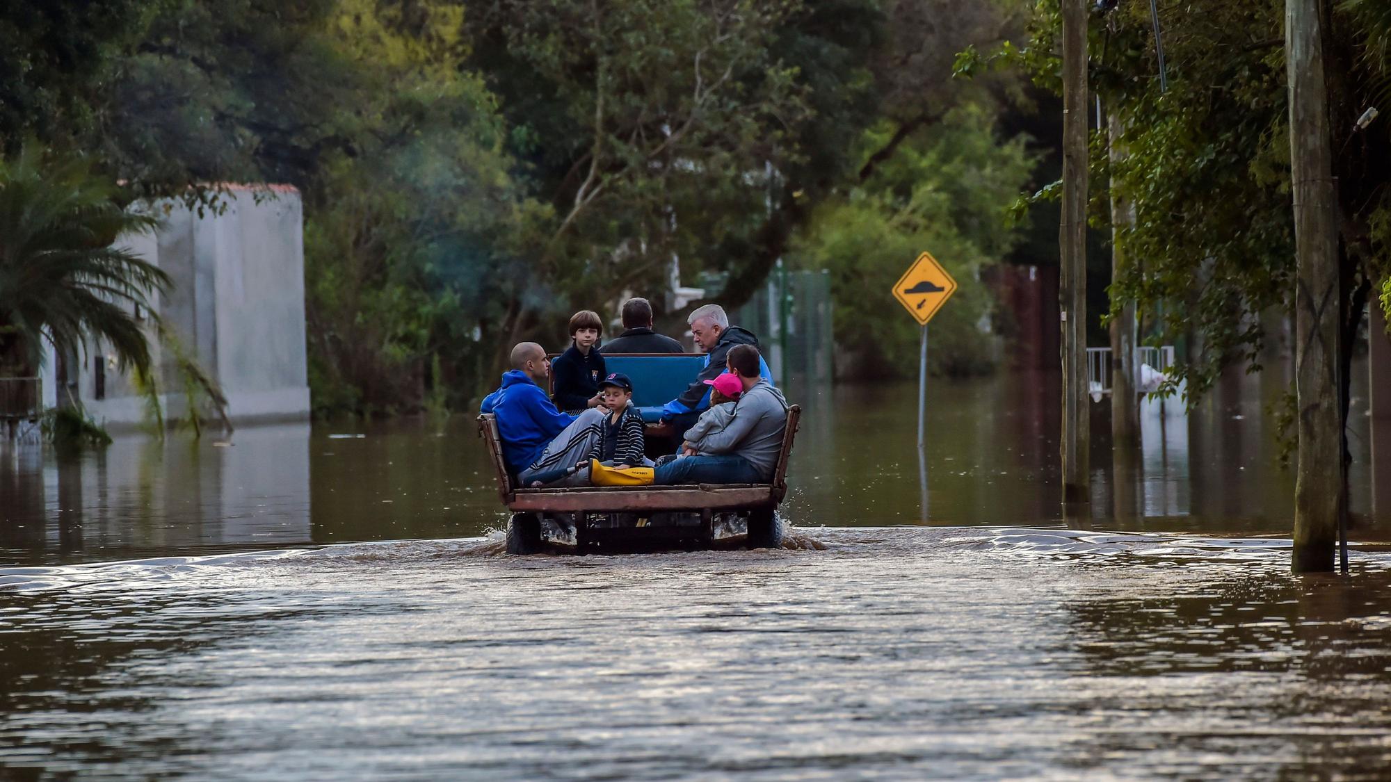 Eine Familie wird im September 2023 in einem Traktor durch eine überschwemmte Straße im Viertel Ilha da Pintada in Porto Alegre im brasilianischen Bundesstaat Rio Grande do Sul transportiert.