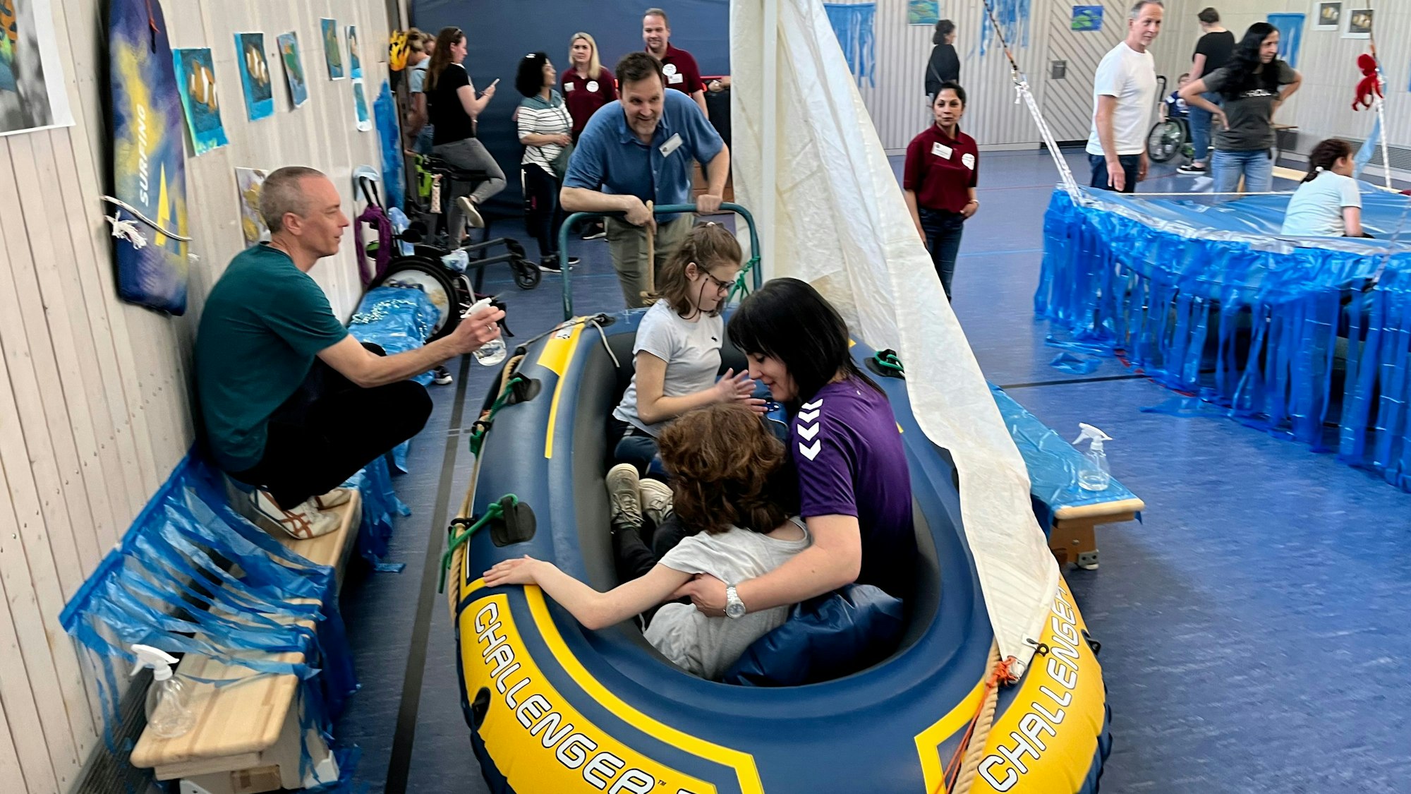 Kinder in einem Schlauchboot in einer Turnhalle