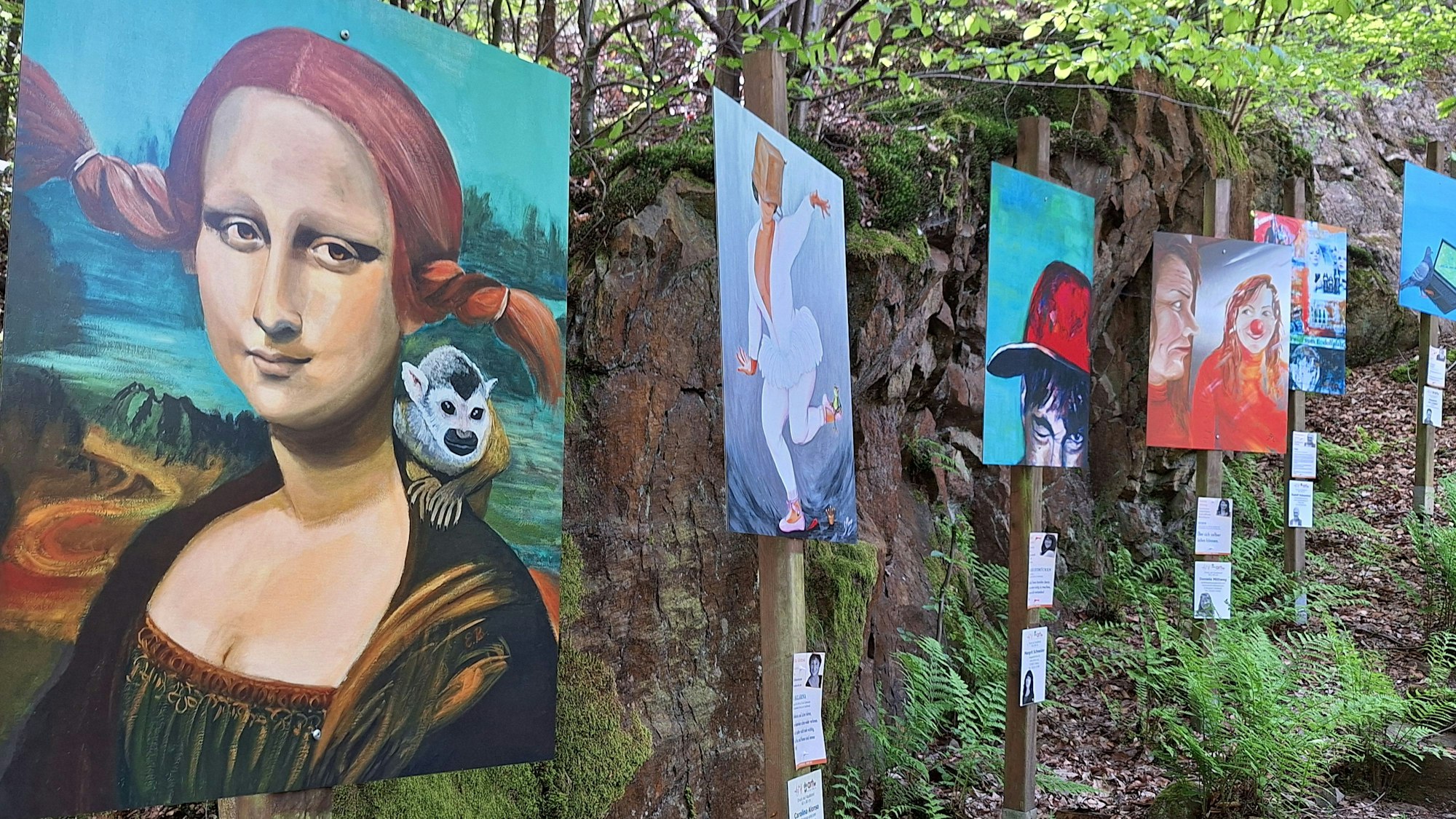 Bilder hängen zwischen Bäumen