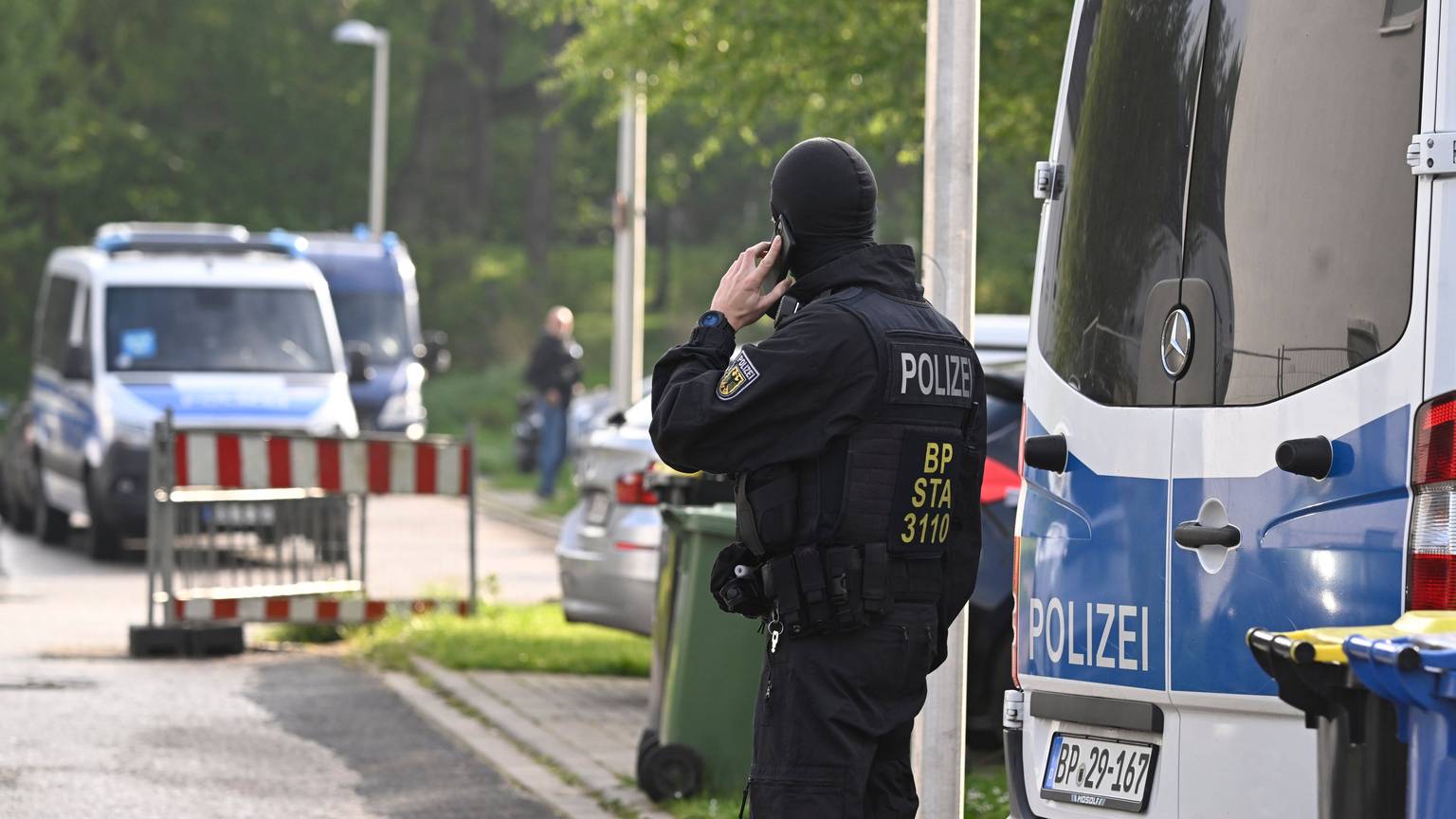 Polizisten durchsuchen im April Wohnungen und Häuser im Rahmen einer Razzia gegen Schleuserkriminalität.