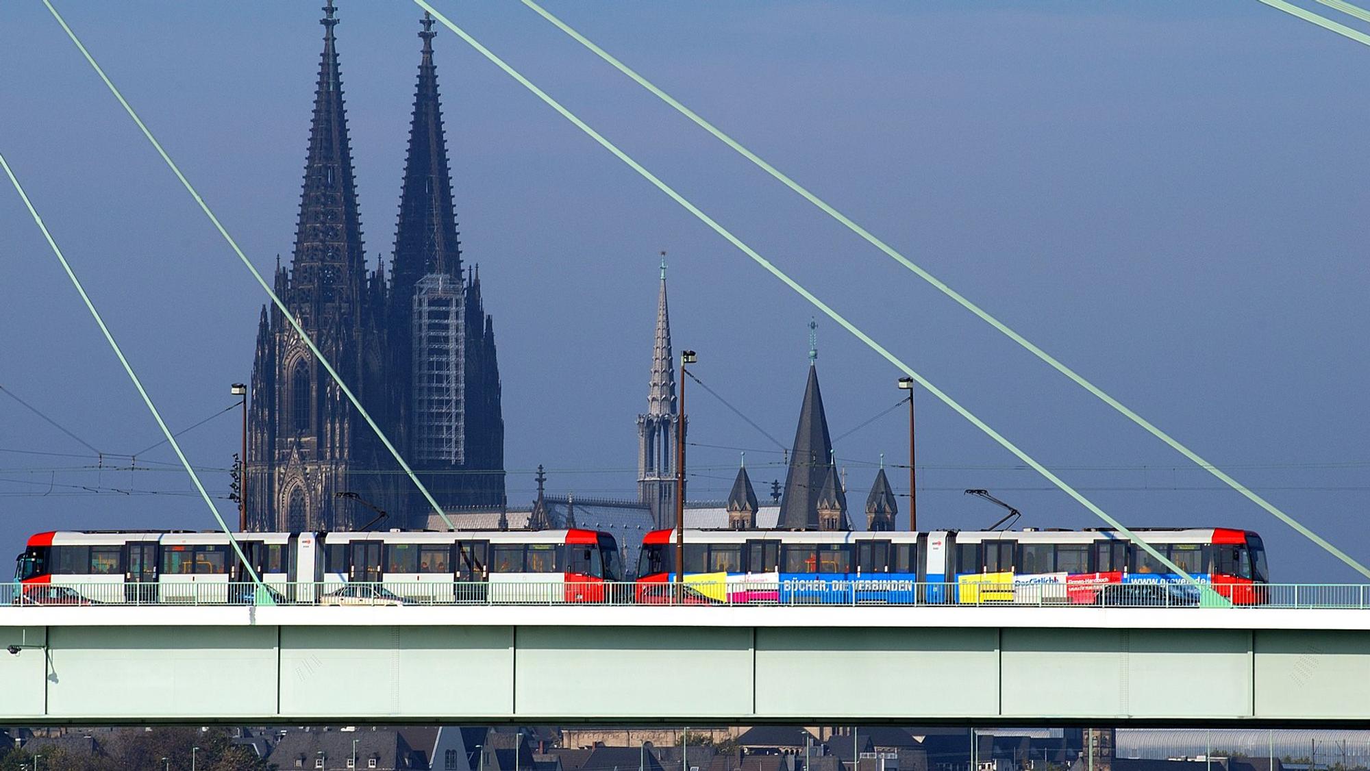 Zu sehen ist eine Stadtbahn der KVB in der Seitenansicht, die über die Severinsbrücke fährt. Im Hintergrund ist der Kölner Dom zu sehen.