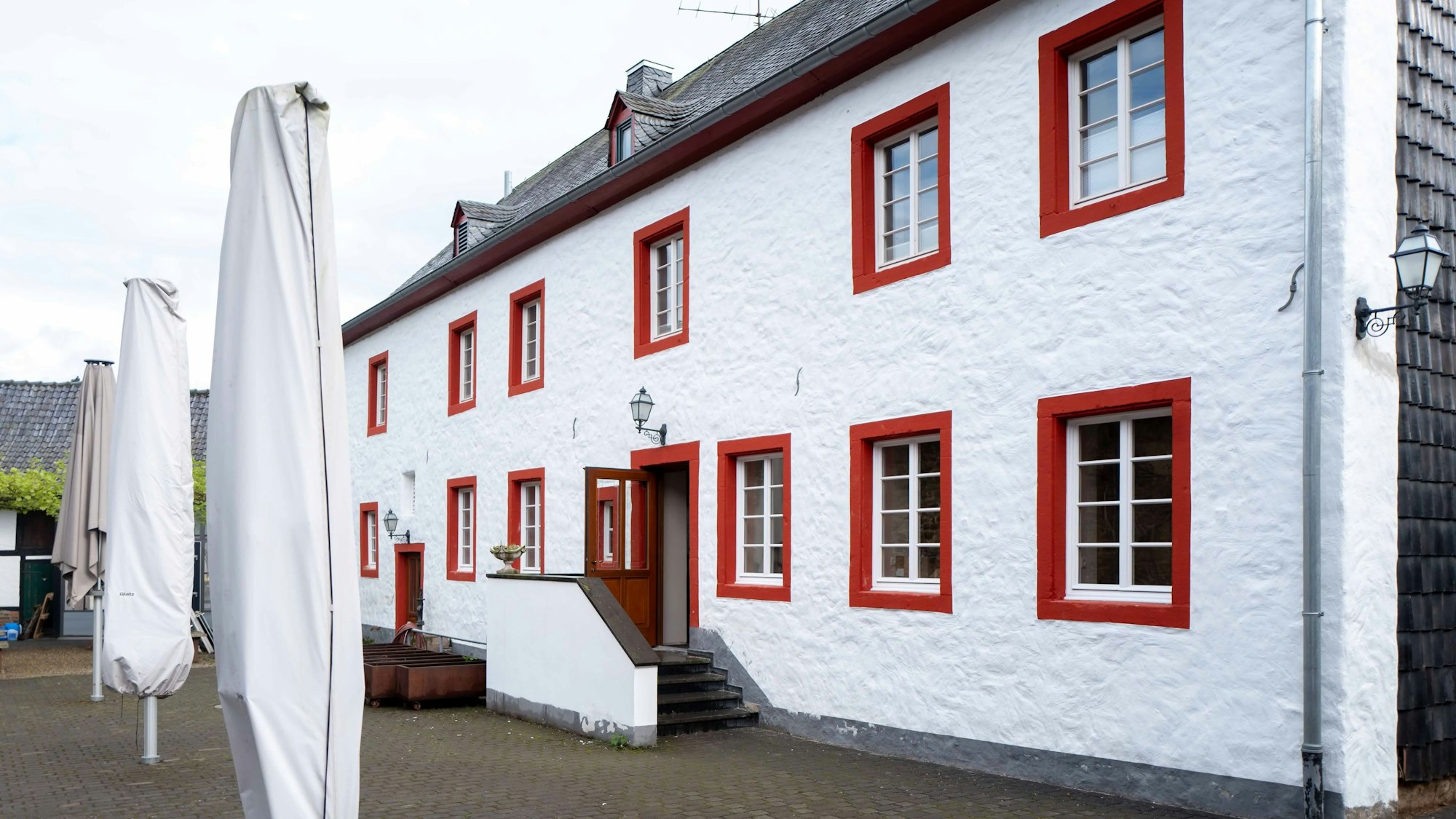 Das Bild zeigt das Brauhaus in Kreuzweingarten. Es ist weiß gestrichen. Die Fensterumrandungen sind rot.