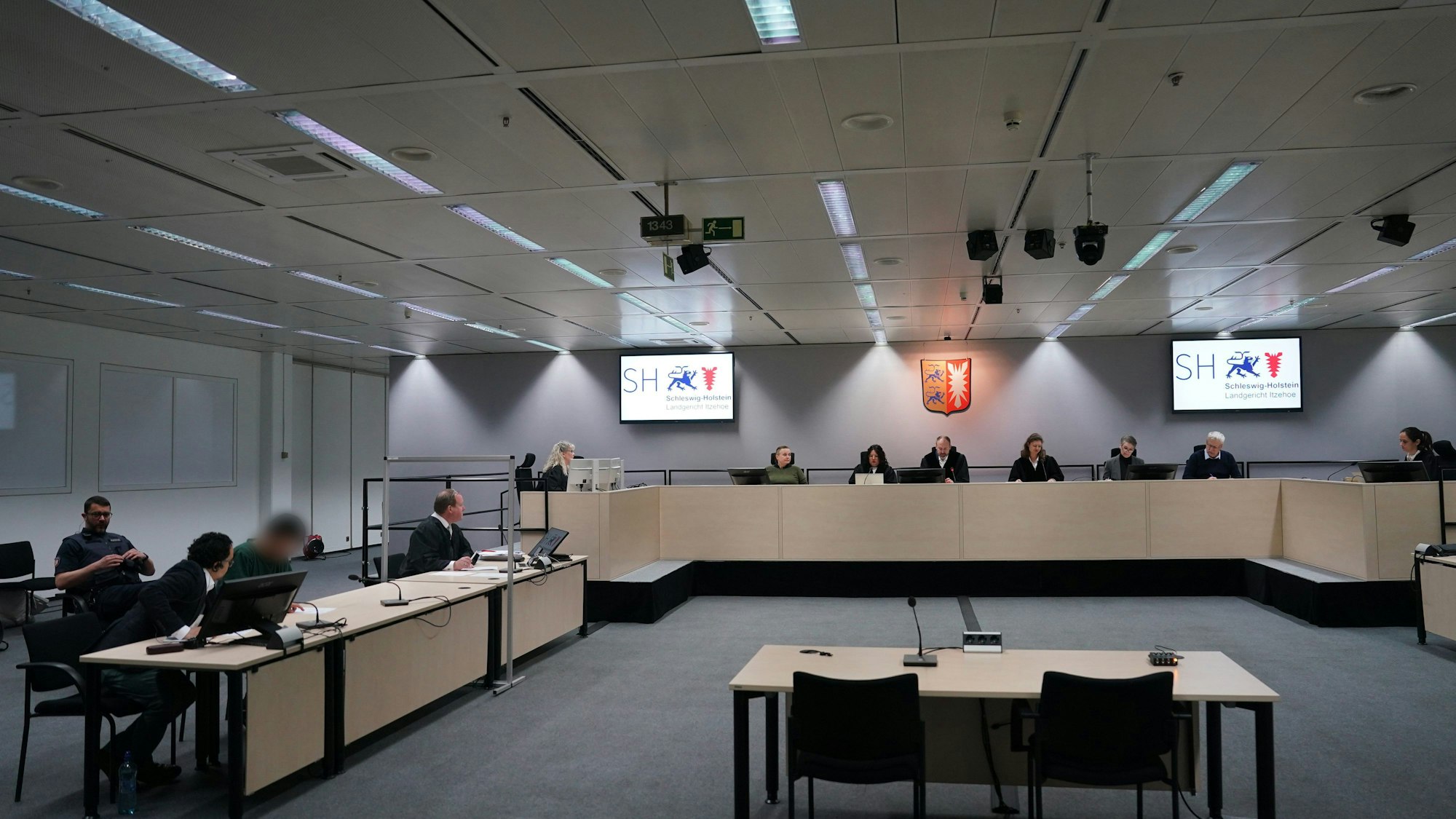 ARCHIV - 15.04.2024, Schleswig-Holstein, Itzehoe: Der Angeklagte Ibrahim A. (3.v.l) sitzt im Gerichtssaal im China Logistic Center neben seinem n Anwalt Björn Seelbach (4.v.l). Im Hintergrund sitzt Johann Christoph Lohmann (5.v.r), Vorsitzender Richter am Landgericht Itzehoe.