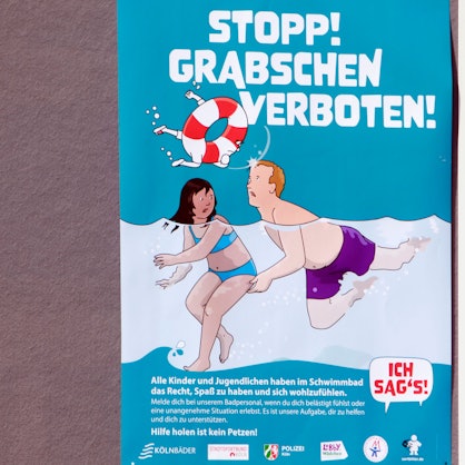 Eines von sechs Kampagnen-Plakaten gegen sexuelle Belästigung in Kölns Schwimmbädern zeigt einen Mann, der einem Mädchen unter Wasser an den Po greift, darüber steht in großen Buchstaben: „Stopp Grabschen verboten!“