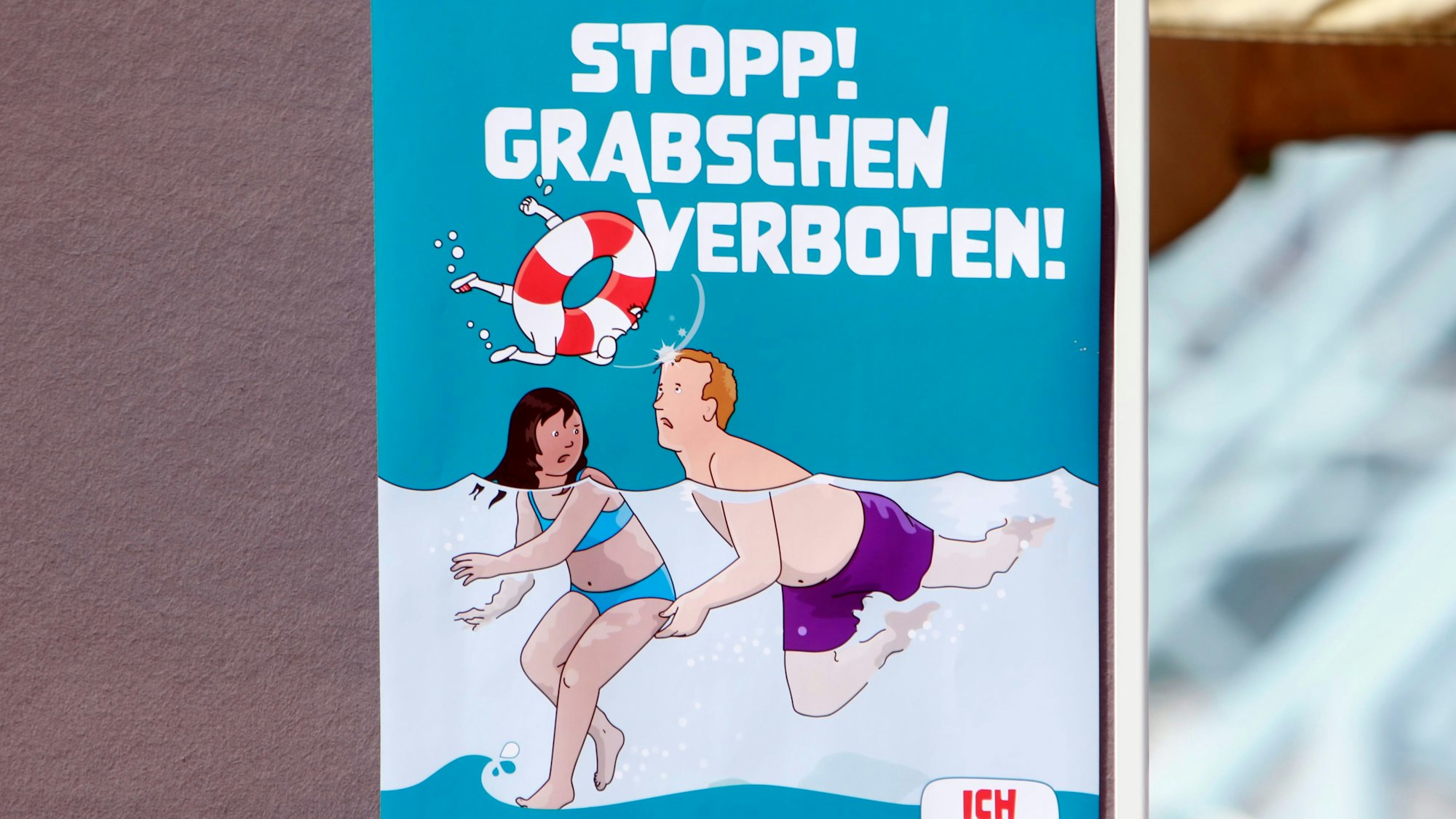 Eines von sechs Kampagnen-Plakaten gegen sexuelle Belästigung in Kölns Schwimmbädern zeigt einen Mann, der einem Mädchen unter Wasser an den Po greift, darüber steht in großen Buchstaben: „Stopp Grabschen verboten!“