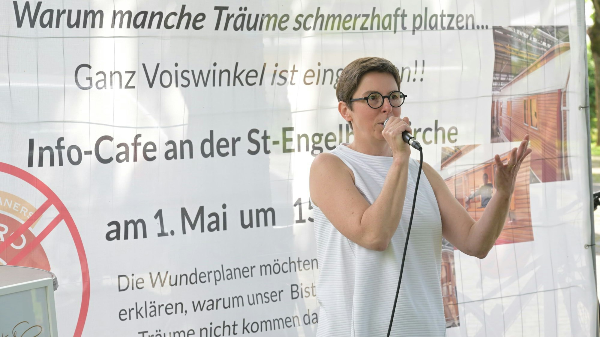 Sonja Tewinkel steht auf einer Bühne und hält ein Mikrofon.