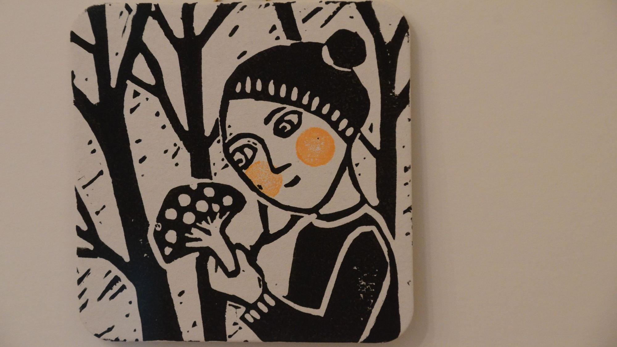 Ein Linoldruck in schwarz-weiß im quadratischen Format eines Bierdeckels. Zu sehen ist ein Mädchen, das in der Hand einen Fliegenpilz hält. Die Wangen des Kindes sind orangerot, die einzige Farbe im Bild.