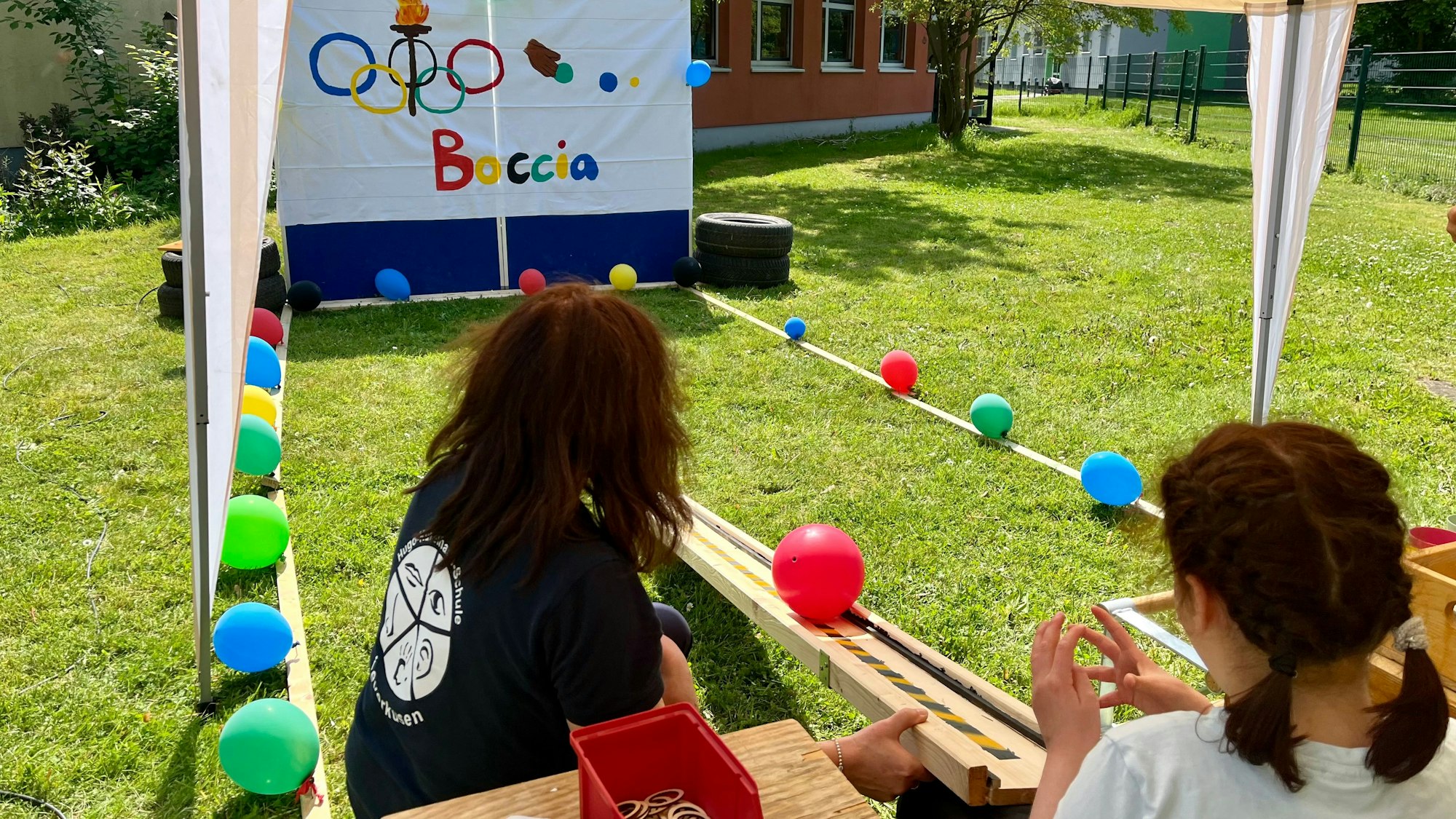 Bunte Luftballons säumen die Boccia-Bahn im Außenbereich.