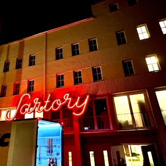 Der leuchtende Sartory-Schriftzug mit einem Truck davor