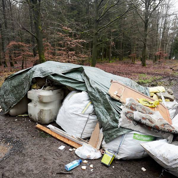 Ein Berg Abfall auf einem Waldweg.