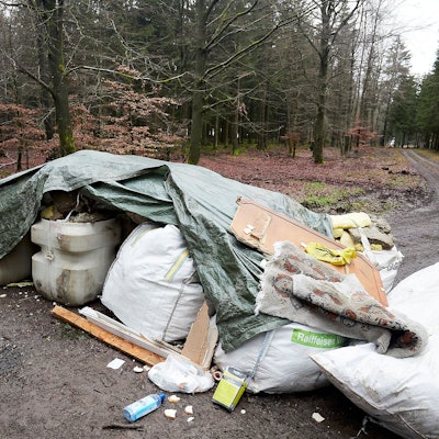 Ein Berg Abfall auf einem Waldweg.