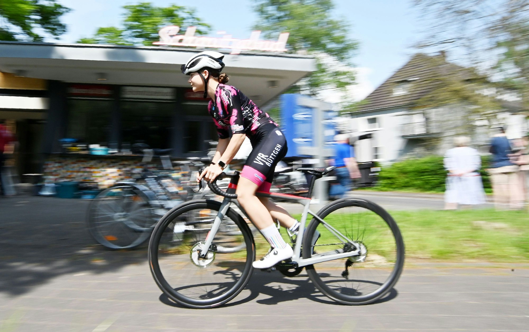 Grete Kirsch fährt auf ihrem Rennrad an der Schmitzebud vorbei.
