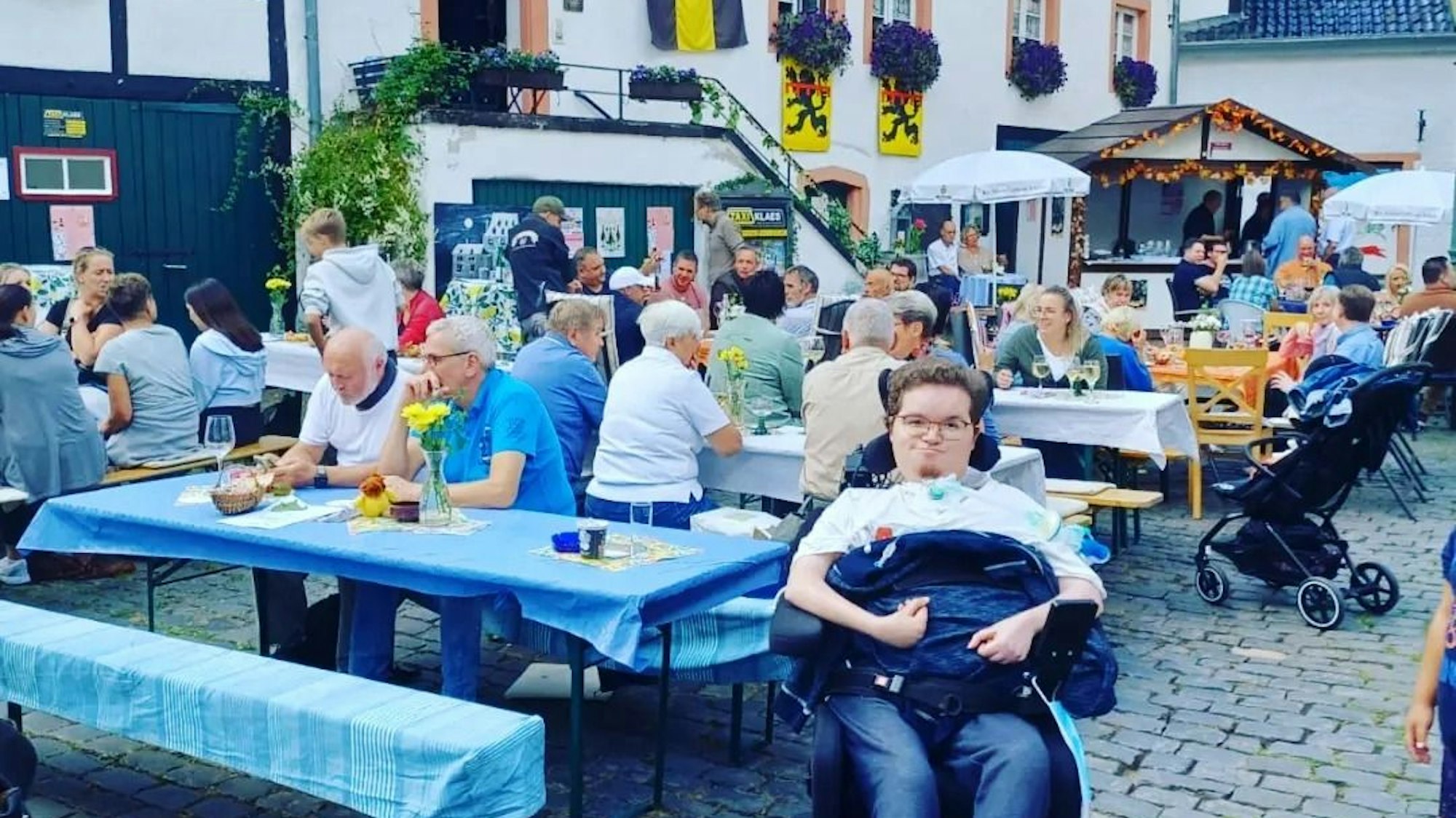 Auf einem Dorffest in Freilingen posiert Simon Hellenthal im Rollstuhl für ein Foto.
