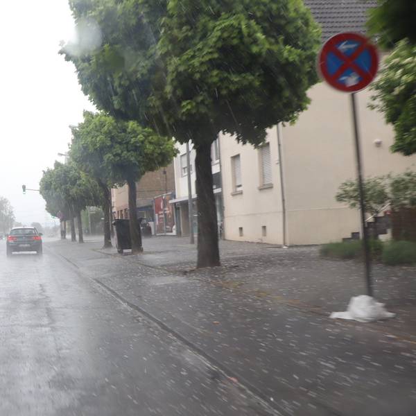 Eine Straße, Regen, Autos und Hagelkörner.