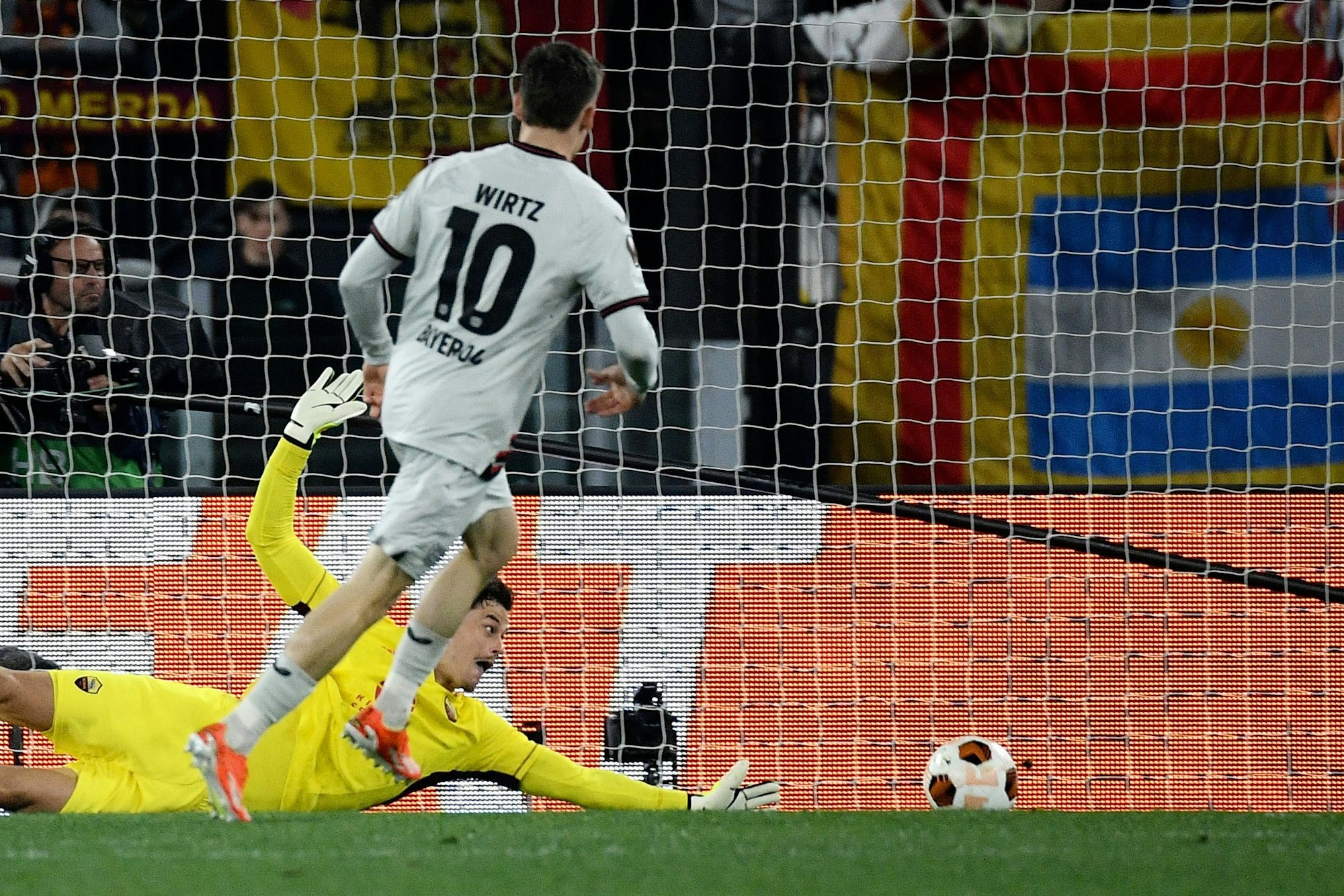 Bayer Leverkusen's German midfielder #10 Florian Wirtz scores his team first goal against Roma's Serbian goalkeeper #99 Mile Svilar during the UEFA Europa League semi final first leg football match between AS Roma and Bayern Leverkusen at the Olympic stadium on May 2, 2024 in Rome. (Photo by Filippo MONTEFORTE / AFP)