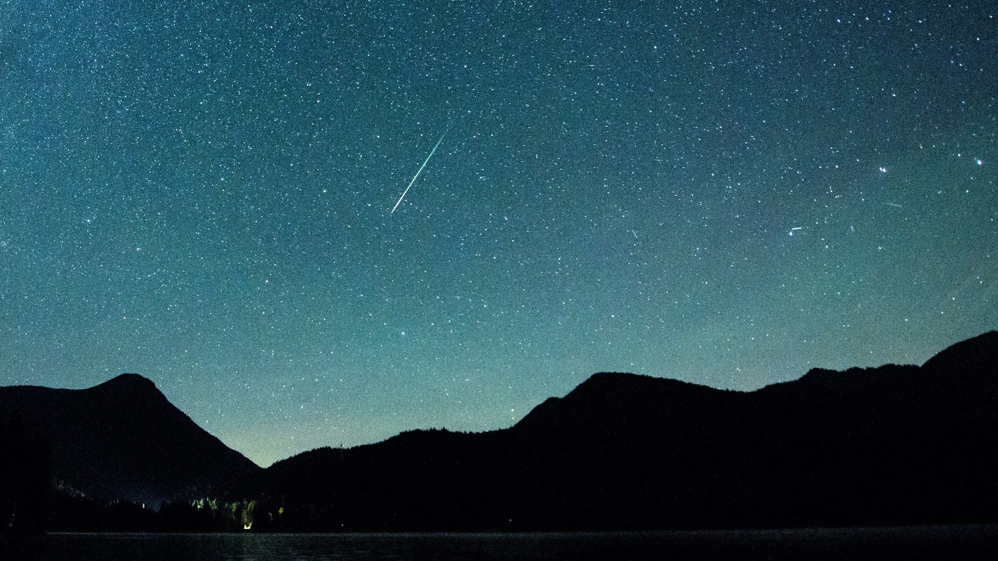 Bayern, Einsiedl: Eine Sternschnuppe leuchtet neben der Milchstraße am Himmel über dem Walchensee. (Archivbild)