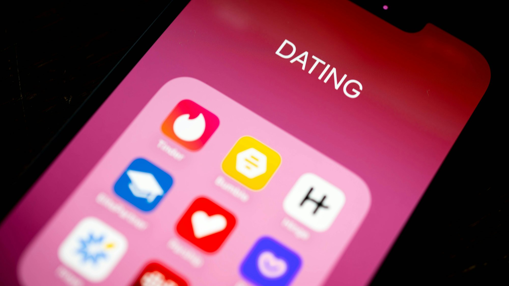 Auf einem Smartphone-Display sind Dating-Apps abgebildet.