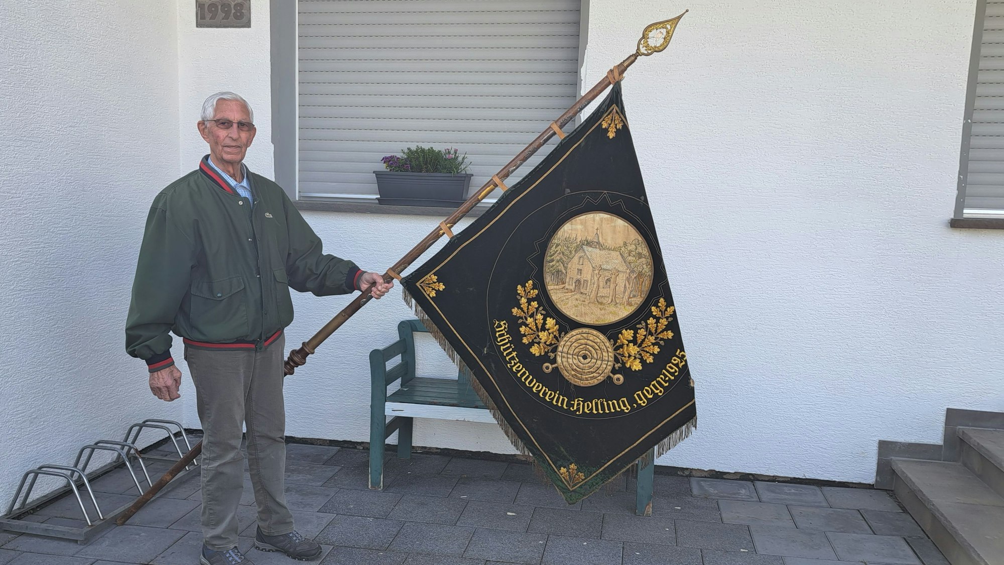 Das Foto zeigt Leo Müller mit der Fahne der Hellinger Schützen.