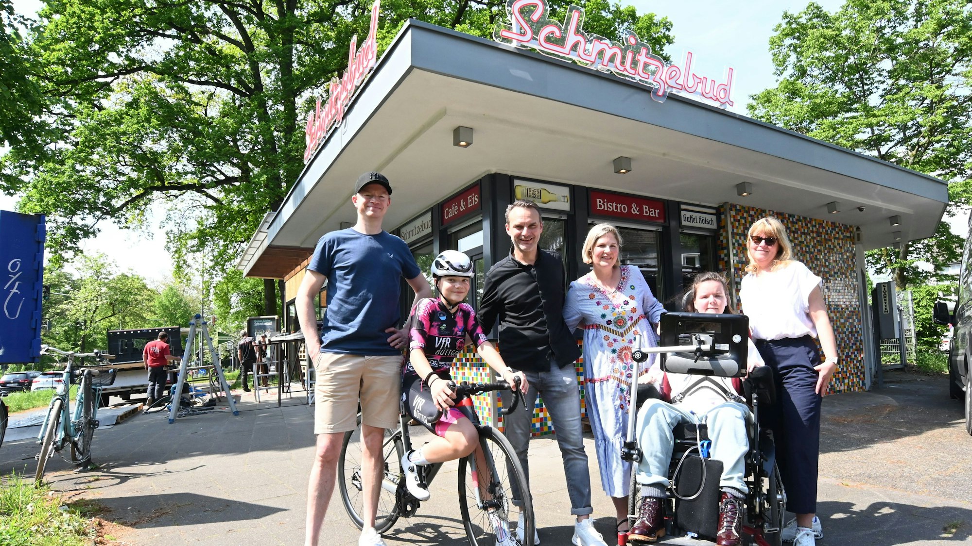 Sechs Menschen stehen vor der Schmitzebud.