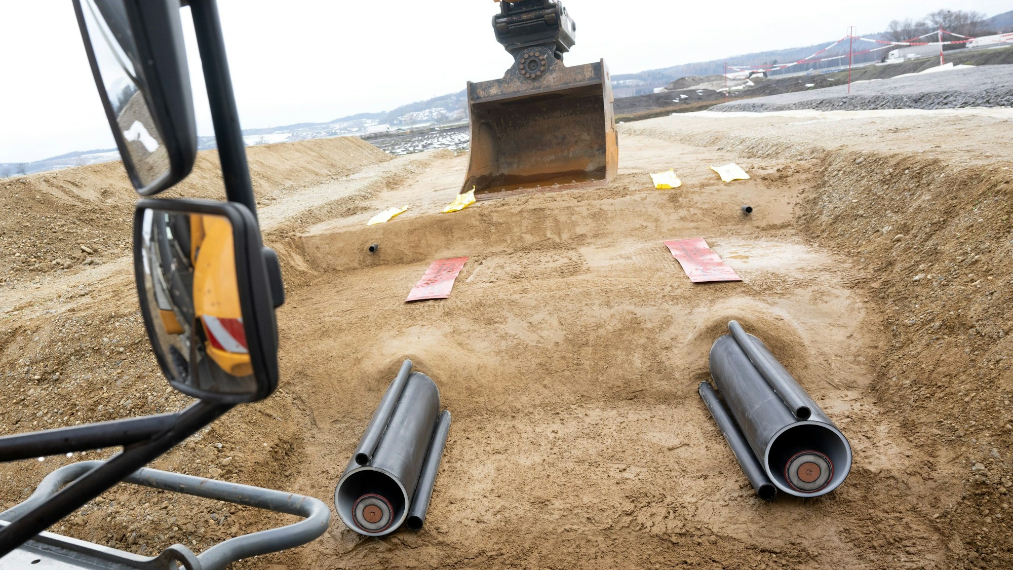 Ein Bagger und zwei Kabel sind während der symbolischen Baustelleneröffnung für die Baumaßnahmen des Südostlinks zu sehen.