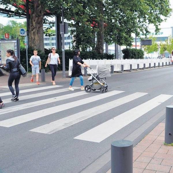Das Foto zeigt Passanten, die die Stationsstraße überqueren